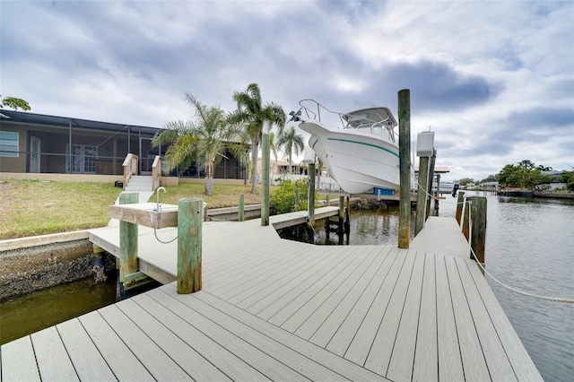 view of dock featuring a lawn and a water view