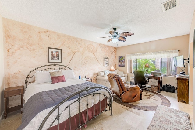 bedroom with ceiling fan and a textured ceiling