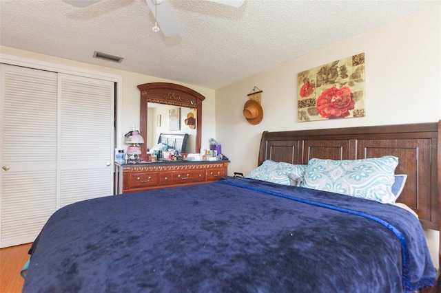 bedroom featuring a textured ceiling, ceiling fan, a closet, and hardwood / wood-style flooring