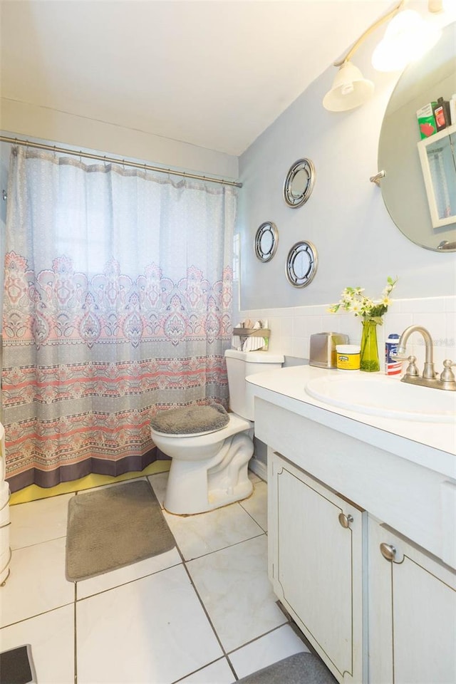 bathroom featuring toilet, vanity, tile walls, and tile patterned floors