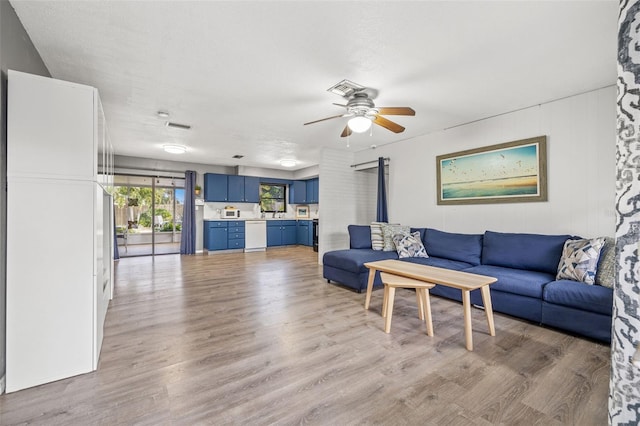 living room with ceiling fan and light hardwood / wood-style floors