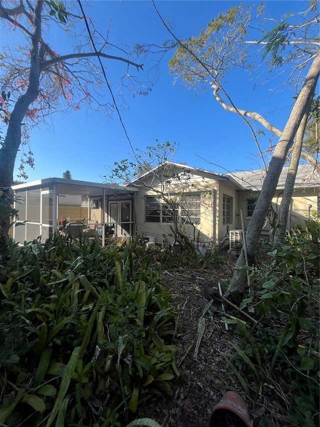 view of property exterior with a sunroom