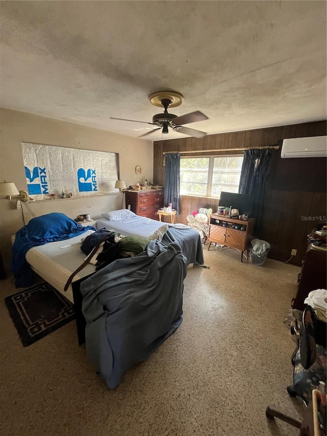 bedroom with ceiling fan, an AC wall unit, a textured ceiling, and wood walls