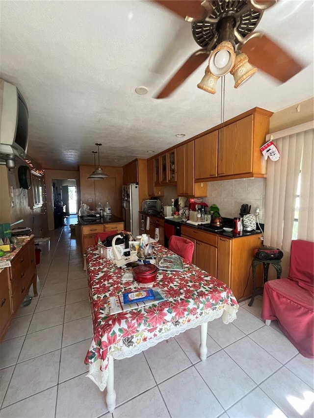 dining space with light tile patterned flooring, ceiling fan, and a textured ceiling