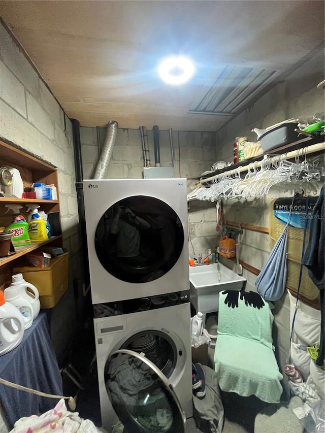 washroom featuring stacked washer and clothes dryer and sink