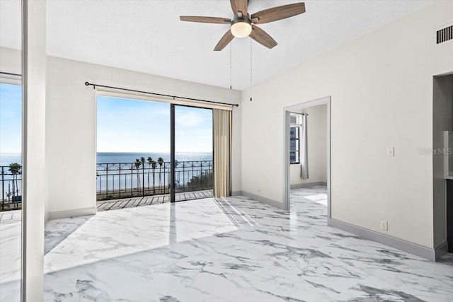 spare room with a water view, ceiling fan, and a textured ceiling