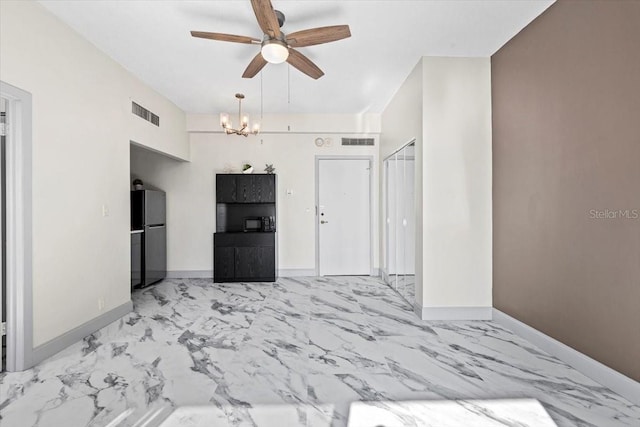 unfurnished bedroom with black fridge, a closet, and ceiling fan with notable chandelier