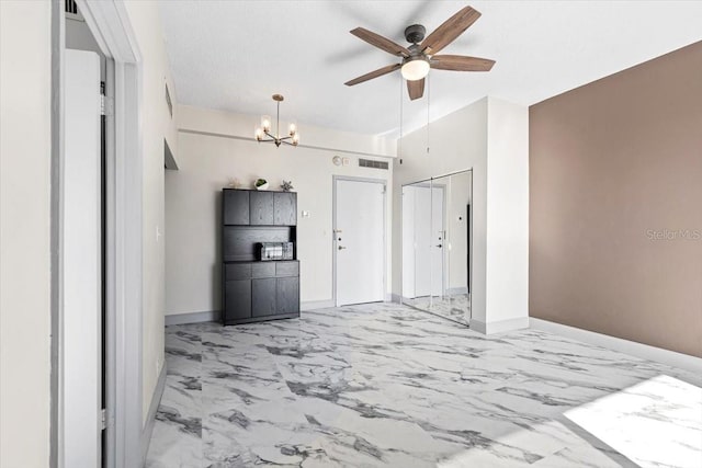 interior space with ceiling fan with notable chandelier