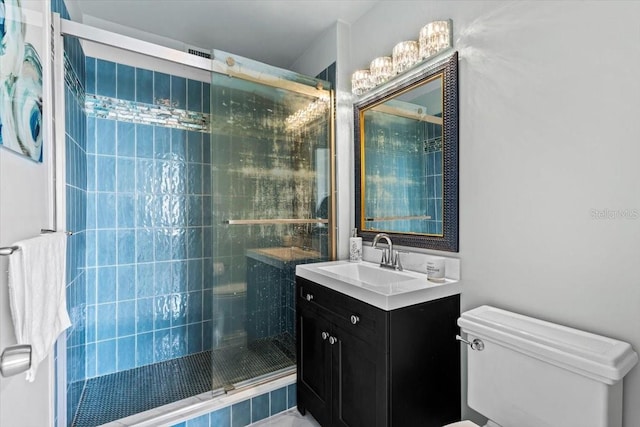 bathroom with toilet, a shower with door, and vanity