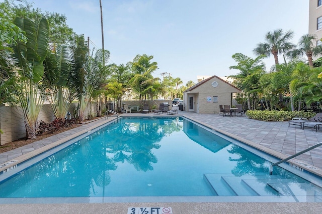 view of pool featuring an outbuilding and a patio