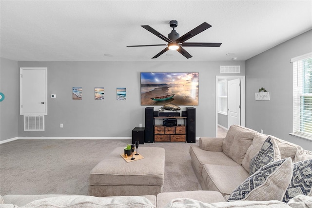 carpeted living room with ceiling fan and a textured ceiling