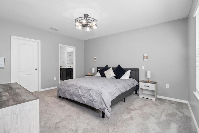 bedroom featuring light carpet, a notable chandelier, and connected bathroom