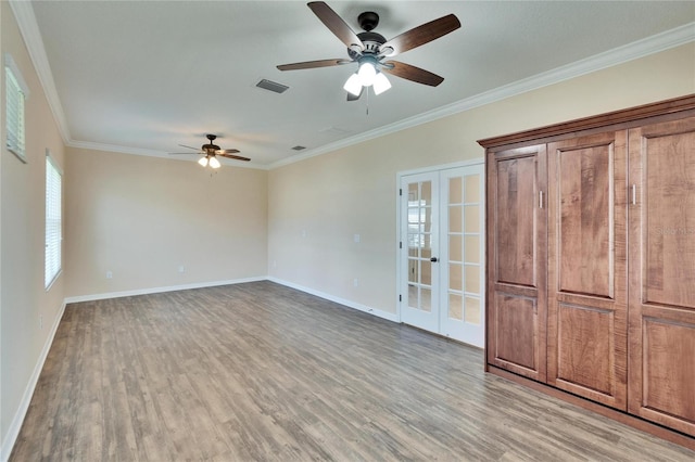 interior space with crown molding, french doors, and light wood-type flooring