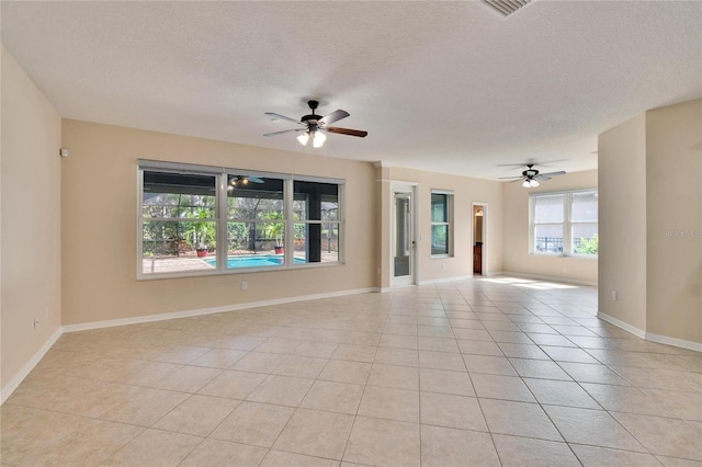 tiled spare room with ceiling fan and a textured ceiling