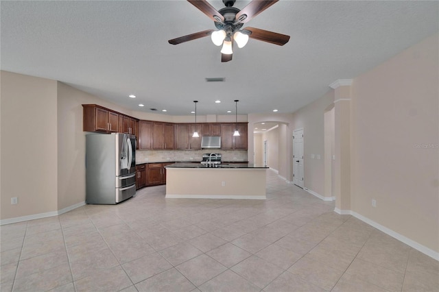 kitchen featuring pendant lighting, a kitchen island with sink, backsplash, stainless steel appliances, and light tile patterned flooring