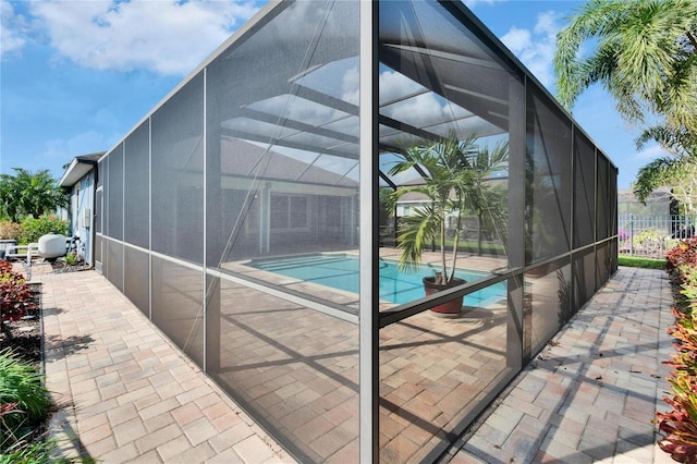 view of swimming pool featuring a patio area and glass enclosure