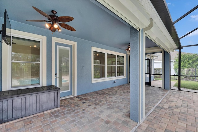 unfurnished sunroom with ceiling fan