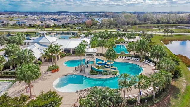 view of pool featuring a water view, a water slide, and a patio