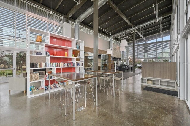 interior space featuring a towering ceiling and concrete flooring