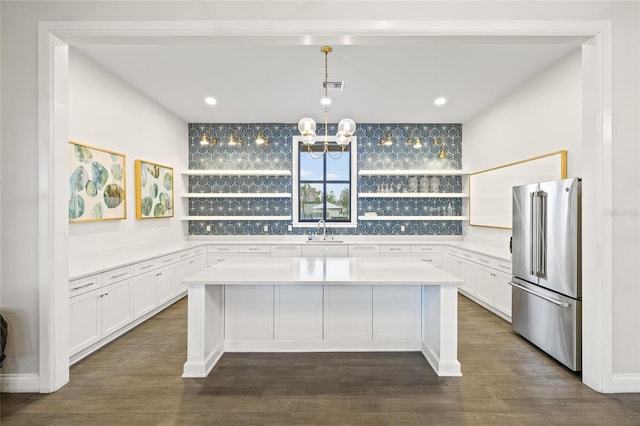 kitchen with white cabinetry, a center island, high end fridge, and sink