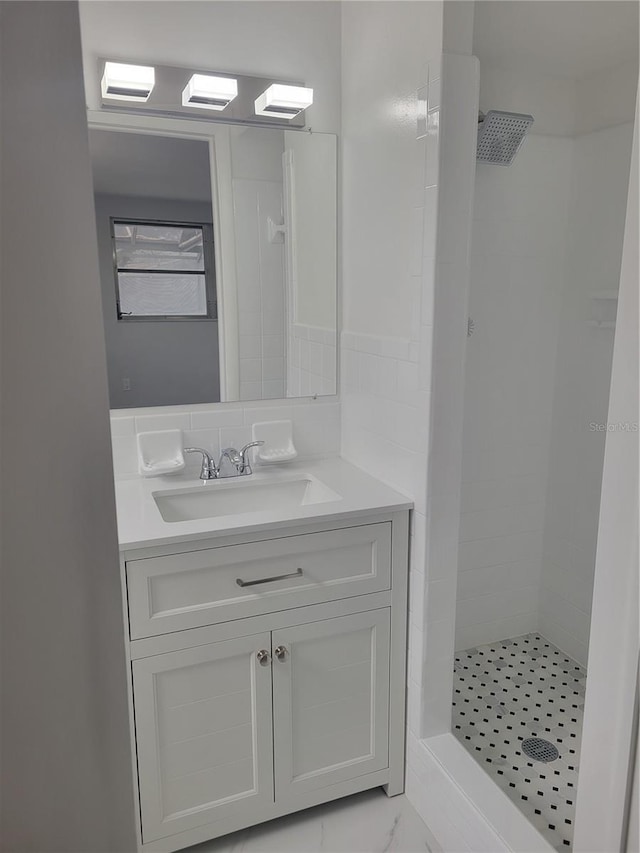 bathroom with vanity and a tile shower