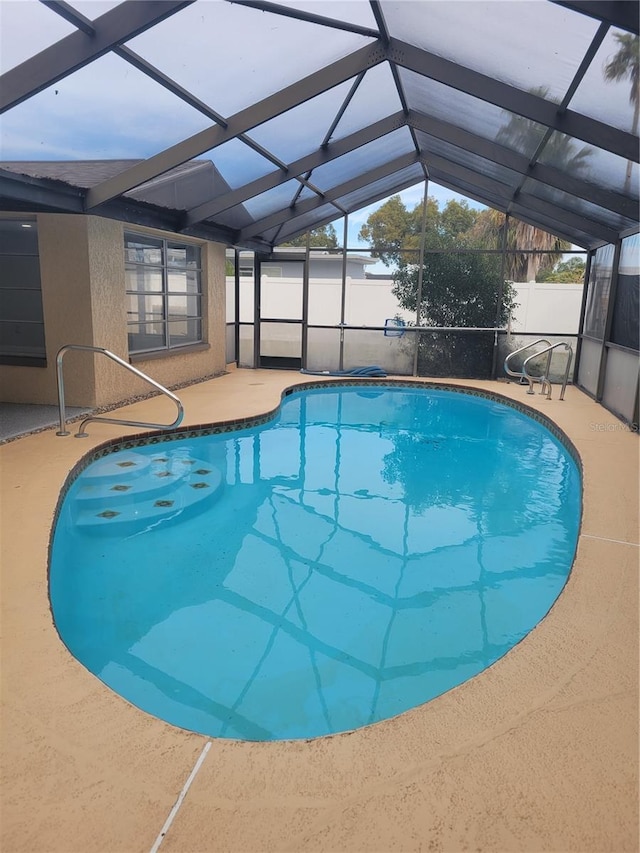 view of swimming pool featuring a lanai and a patio