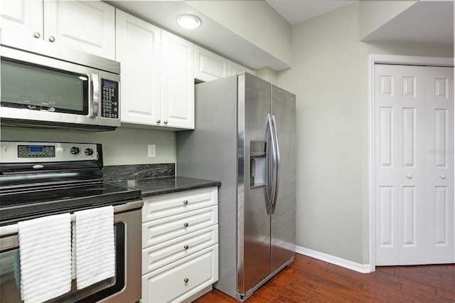 kitchen with white cabinetry, dark hardwood / wood-style flooring, stainless steel appliances, and dark stone countertops