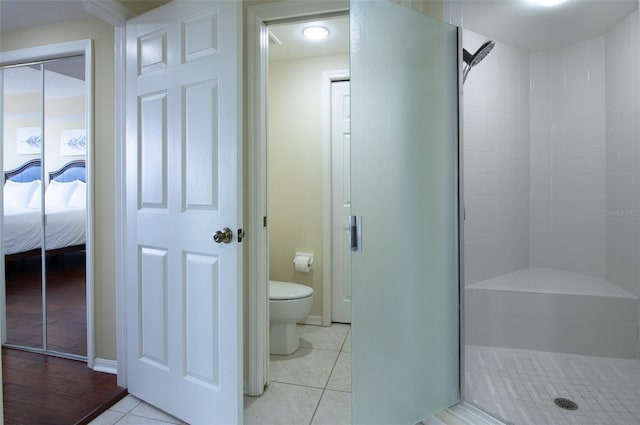 bathroom featuring an enclosed shower, tile patterned floors, and toilet