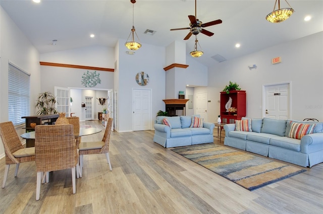 living room featuring ceiling fan, high vaulted ceiling, and light hardwood / wood-style floors