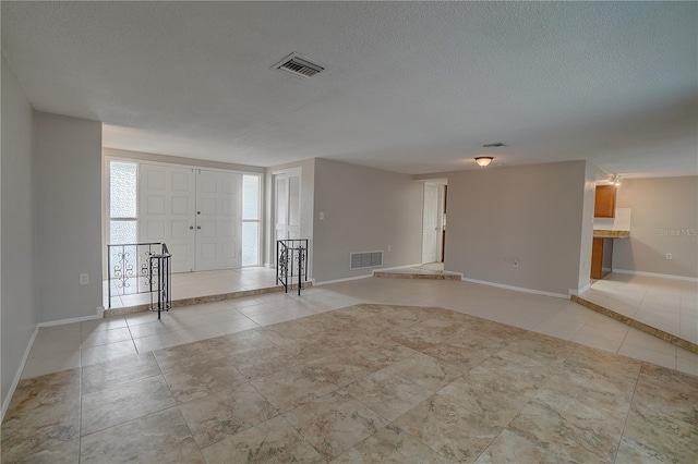 tiled entrance foyer featuring a textured ceiling