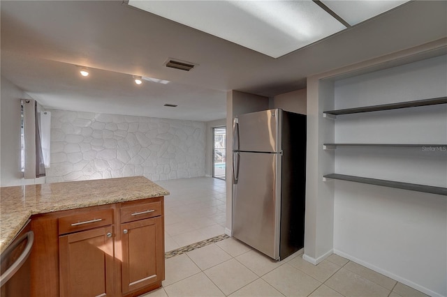 kitchen featuring stainless steel appliances, light tile patterned floors, and light stone counters