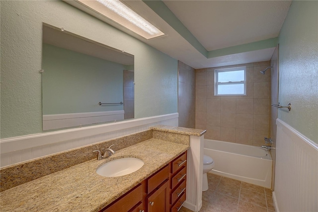 full bathroom with vanity, tiled shower / bath, tile patterned flooring, and toilet