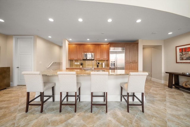 kitchen with sink, a breakfast bar, appliances with stainless steel finishes, and a large island