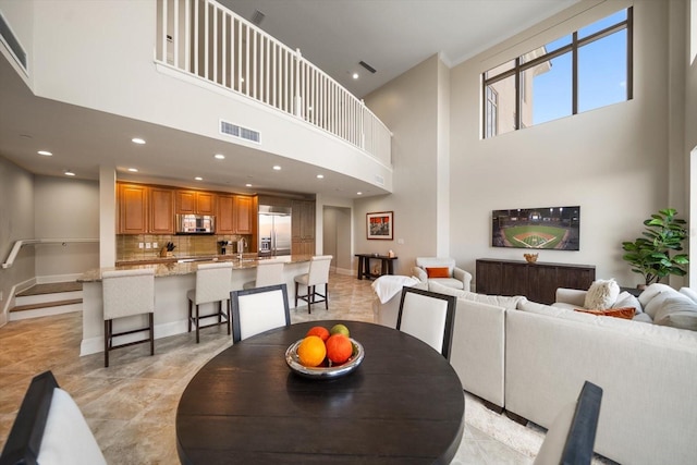 dining room with light tile patterned flooring and a high ceiling