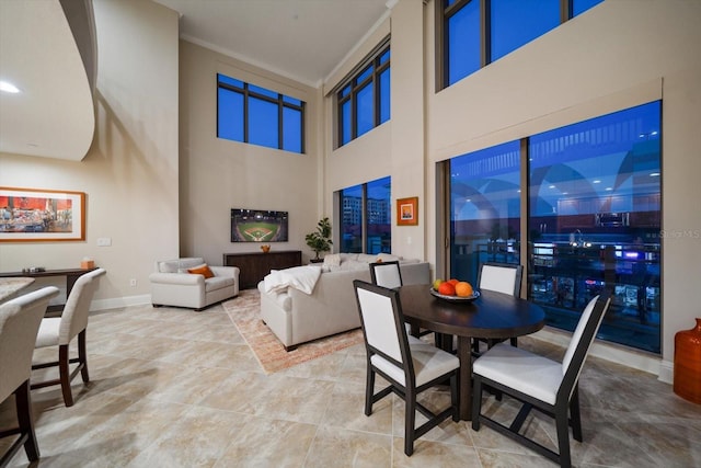 dining area featuring a towering ceiling and crown molding