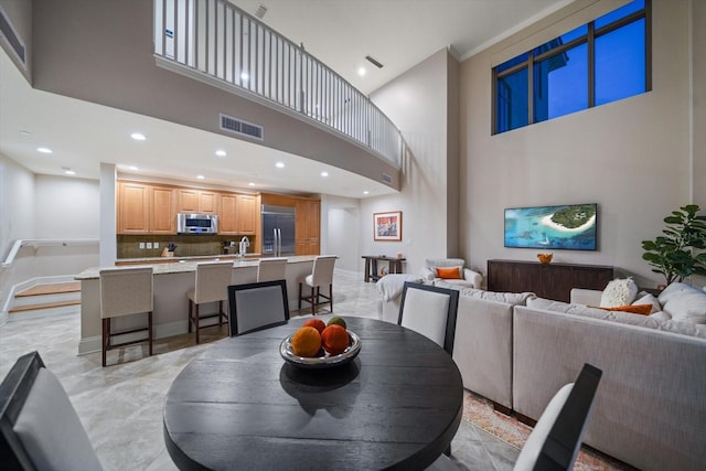 dining space with sink and a high ceiling