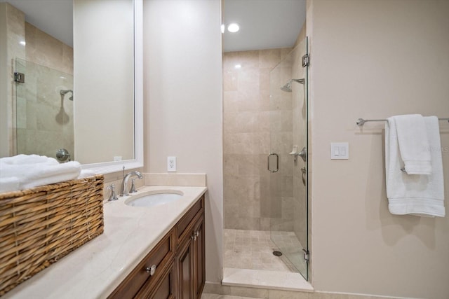 bathroom featuring walk in shower and vanity