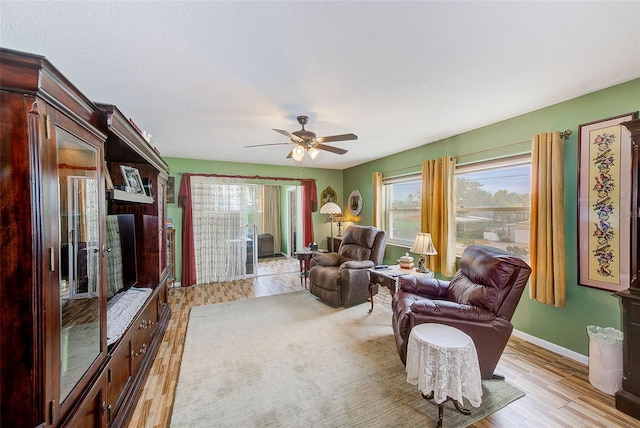 living room with light hardwood / wood-style floors and ceiling fan