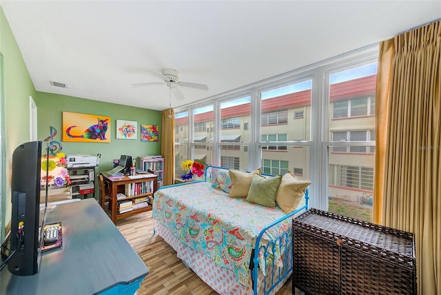 bedroom with ceiling fan, a wall of windows, and light wood-type flooring