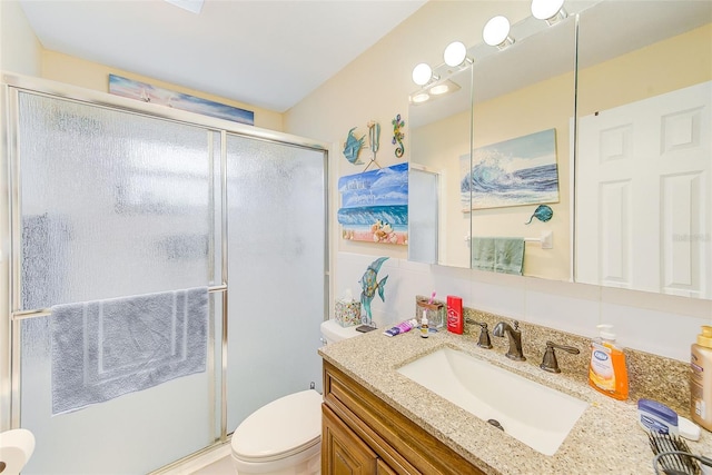 bathroom featuring vanity, toilet, and an enclosed shower