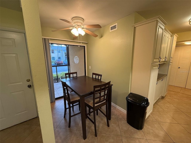 tiled dining space with ceiling fan