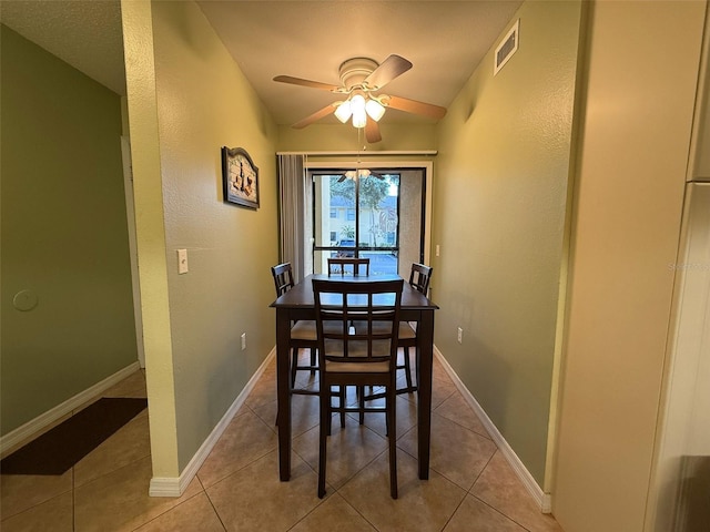 dining area with ceiling fan, vaulted ceiling, and light tile patterned flooring