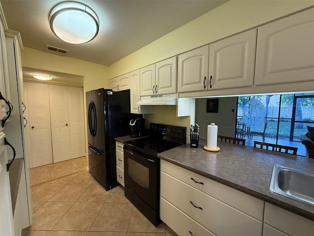 kitchen with sink, black appliances, white cabinetry, and light tile patterned floors