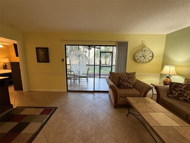 living room with a textured ceiling and light tile patterned flooring