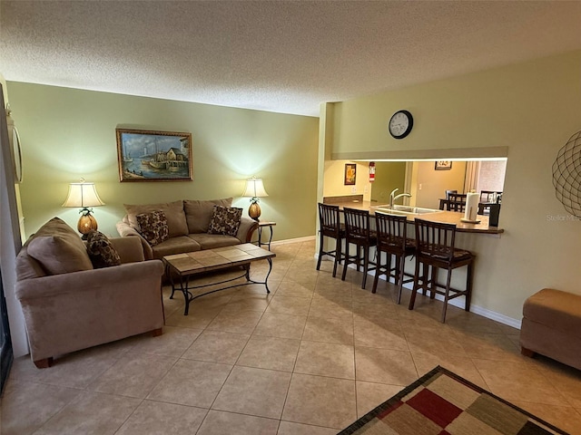 tiled living room with sink and a textured ceiling