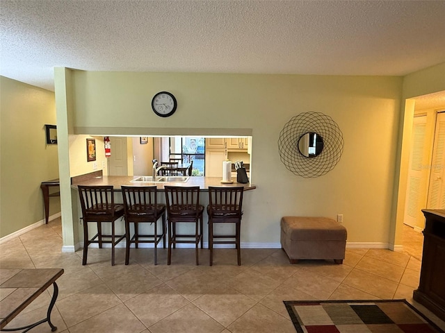 tiled dining room featuring a textured ceiling