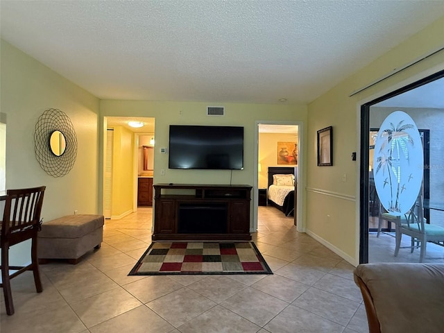 living room with light tile patterned flooring and a textured ceiling