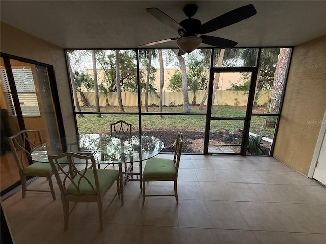 unfurnished sunroom with ceiling fan