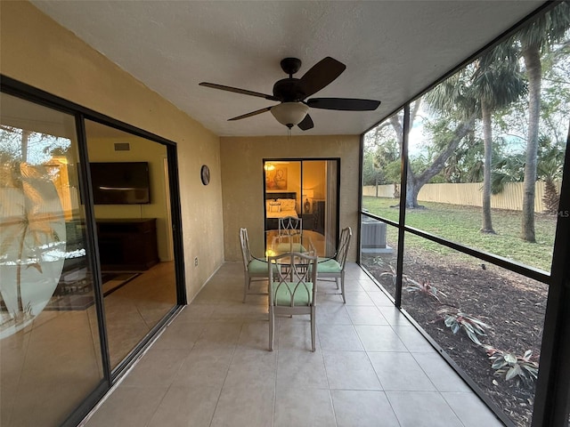 unfurnished sunroom with ceiling fan