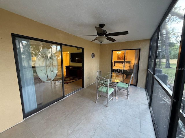 unfurnished sunroom with ceiling fan and plenty of natural light